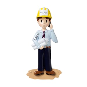 May include: A personalized ornament of a cartoon construction worker wearing a yellow hard hat with the word "YEAR" on it. The worker is holding blueprints and talking on a phone. The ornament is personalized with the name "Chris".