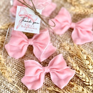 May include: Pink satin bows with a thank you tag that reads "Thank you Kayla's Baby Shower 08/12/24".