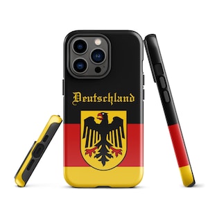 Puede incluir: Una funda de teléfono negra con un diseño de bandera alemana. La funda presenta los colores de la bandera alemana, negro, rojo y amarillo, junto con el escudo de armas alemán, que incluye un águila negra. El texto "Deutschland" está impreso en dorado sobre la bandera.