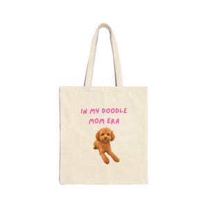 May include: A white ceramic mug with a black handle and the text "But First, Coffee" in a black, bold font. The mug is on a white surface.