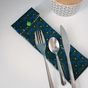 Peut inclure: Un étui en tissu bleu et vert à motifs avec une fermeture à pression contient une fourchette, une cuillère et un couteau. L'étui est fait d'un tissu résistant et est parfait pour transporter des couverts en déplacement.