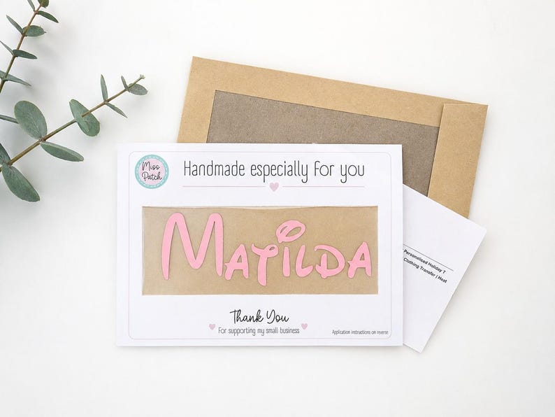 K&ouml;nnte beinhalten: Eine wei&szlig;e rechteckige Karte mit dem Text Handmade especially for you und Thank You for supporting my small business, mit einem mittigen Ausschnitt, der einen rosa B&uuml;geltransfer mit dem Namen Matilda und einen braunen Umschlag zeigt.