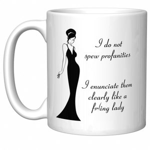 May include: White ceramic coffee mug with a black and white illustration of a woman in a long dress. The mug has the text "I do not spew profanities I enunciate them clearly like a f#ing lady" printed on it.