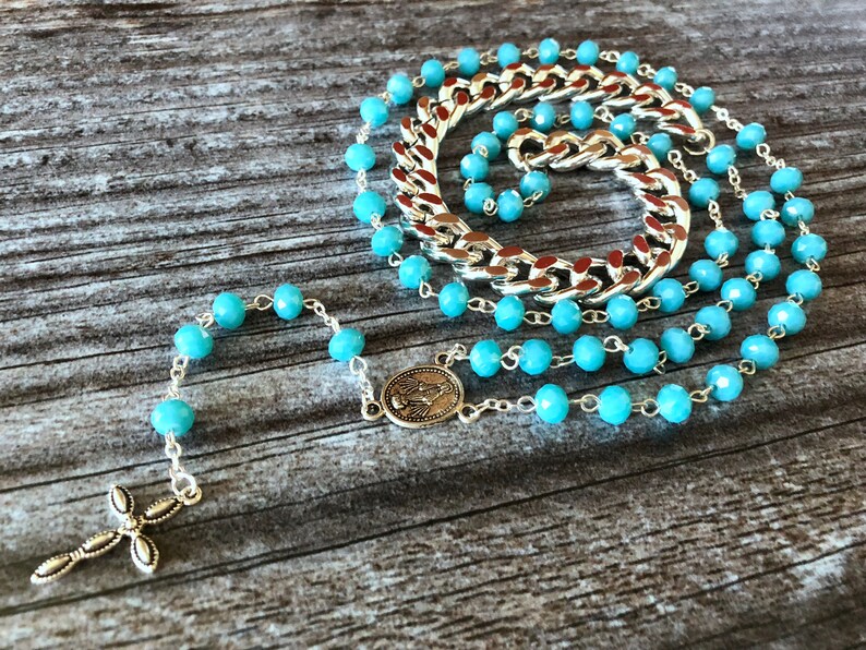 Light blue rosary style necklace with crystal beads and chain.