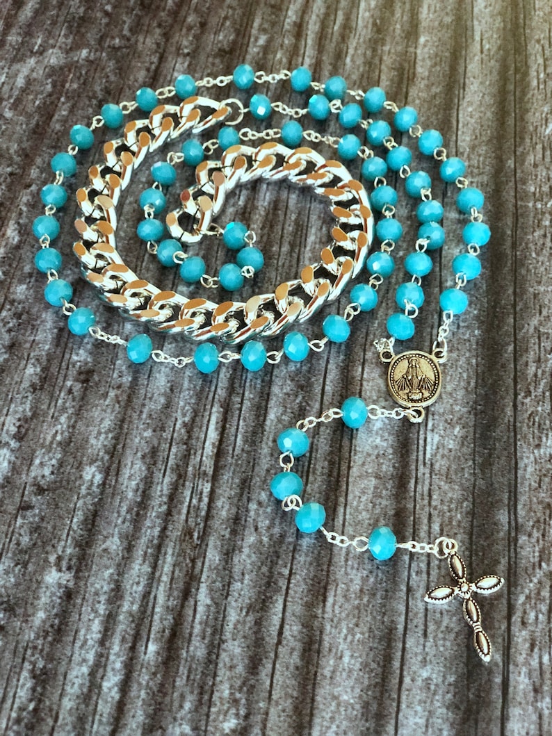 Light blue rosary style necklace with crystal beads and chain.