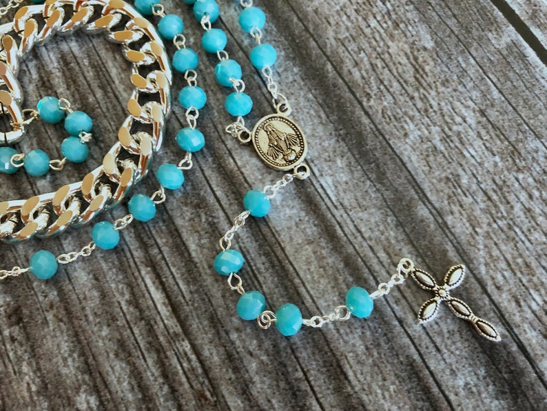 Light blue rosary style necklace with crystal beads and chain.
