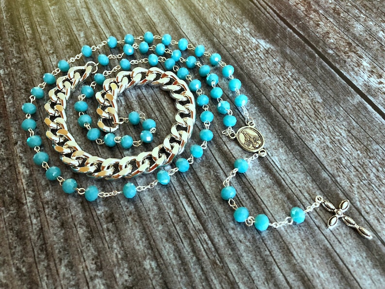 Light blue rosary style necklace with crystal beads and chain.