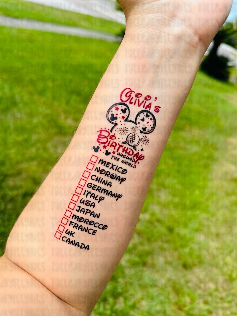 May include: A red and black temporary tattoo with a Mickey Mouse head and the text "Olivia's Birthday Around the World". The tattoo also includes a list of countries with checkboxes next to them, including Mexico, Norway, China, Germany, Italy, USA, Japan, Morocco, France, UK, and Canada.