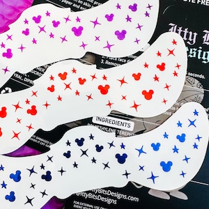 May include: White eye mask stickers decorated with purple, red, and blue Mickey Mouse heads and stars. The stickers are on a purple background with black packaging that includes instructions and ingredients.