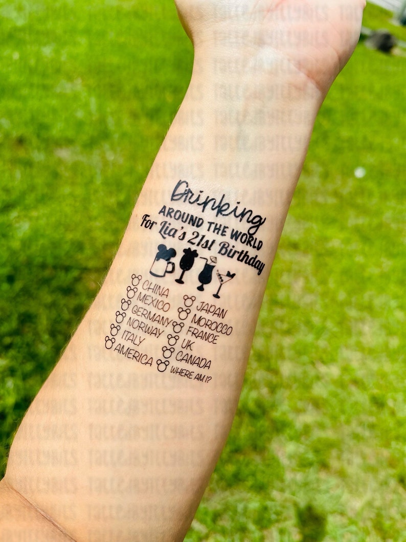 May include: A temporary tattoo with the text "Drinking around the world for Lia's 21st Birthday" and a list of countries including China, Mexico, Germany, Japan, Morocco, France, Norway, UK, Italy, Canada, and America. The tattoo also includes a Mickey Mouse head and a cocktail glass.
