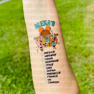 May include: A temporary tattoo with the text "Alexa's Drink Around the World Tour" and a list of countries including Mexico, Norway, China, Germany, Italy, USA, Japan, Morocco, France, UK, and Canada.