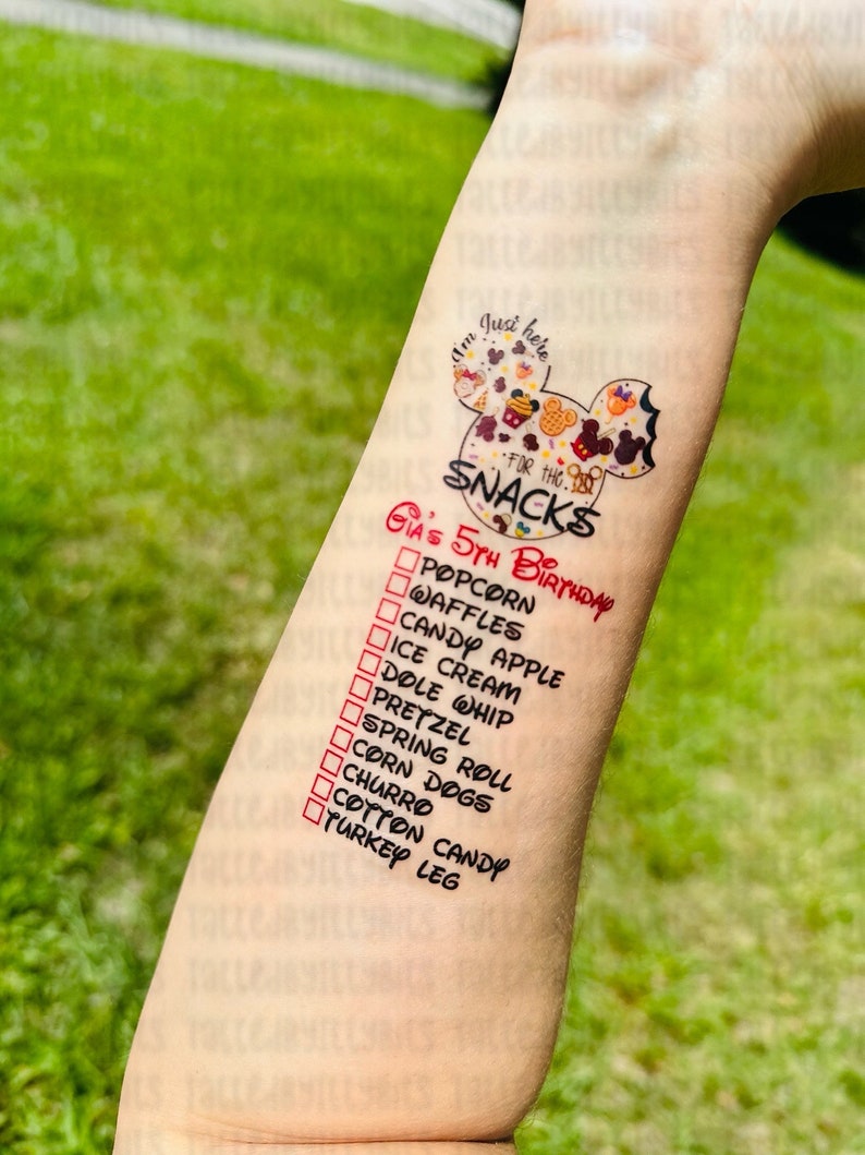May include: A white Mickey Mouse head with a red border and the text "I'm Just Here For The Snacks" inside. Below the Mickey Mouse head is a list of snacks with checkboxes next to each item. The list includes popcorn, waffles, candy apple, ice cream, dole whip, pretzel, spring roll, corn dogs, churro, cotton candy, and turkey leg. The text "Gia's 5th Birthday" is written in red above the list.