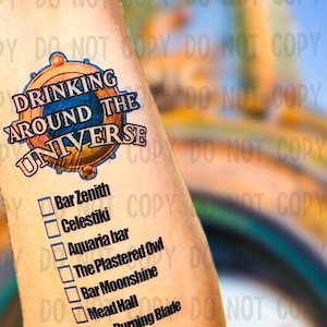 May include: A temporary tattoo with a colorful logo that says "Drinking Around the Universe" and a list of bars to visit: Bar Zenith, Celestiki, Aquaria bar, The Plastered Owl, Bar Moonshine, Mead Hall, The Burning Blade.