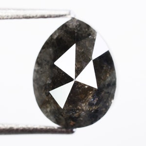 Op de afbeelding: Een peervormige zwarte diamant met een facetgeslepen ontwerp. De diamant heeft een donkergrijze kleur met witte facetten.