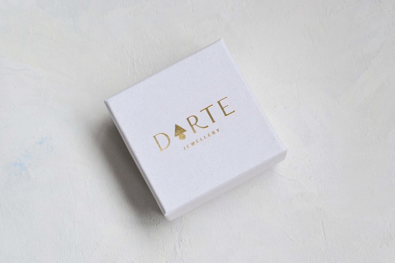 May include: A white square box with the gold text "Darte Jewellery" printed on the top.