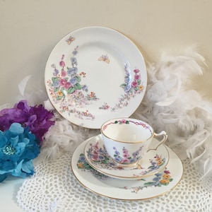 tasse à thé et soucoupe/assiettes Crown Staffordshire Hollyhocks vintage, porcelaine anglaise vers 1930, tasse à thé florale blanche avec papillons et rebord doré