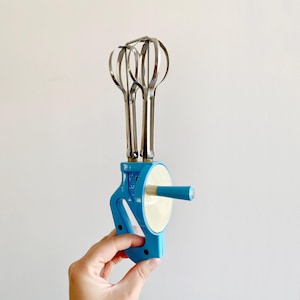 Vintage manual mixer in light blue and white plastic and metal whisks