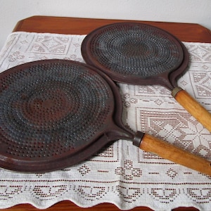 Le brûleur de poêle diffuse la chaleur avec un manche en bois, un dessous de plat, un huilier et un protège-casseroles. batterie de cuisine vintage du milieu du siècle. État rustique.