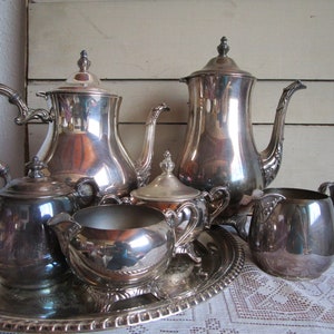 WM Rogers silverplated tea service. Tray, two creamers, sugar bowls, tea, coffee pots. One pot distressed. Lot or indiv. Ship incl in US.