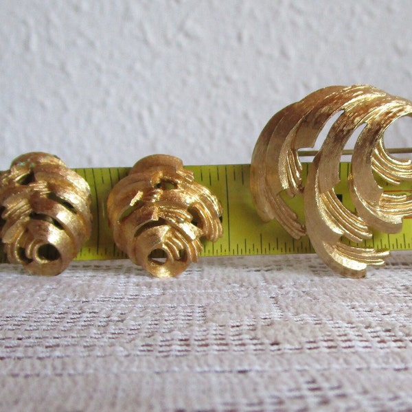 Gold tone swirl brooch and earrings. Monet 1980's Abstract geometric clip on earrings and pin. Gently used. Ship incl in US