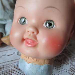 1940s doll head detached with stuffed/soft body. Doll parts in distressed condition.