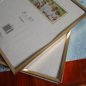 Gold tone 8x10 metal frames mid-century. Hinge table top backs. Vintage 1980s new condition with signs of aging. Minimal office or home.