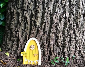 Outdoor fairy and elf door in yellow, with personalised sign post. Spring yellow miniature door