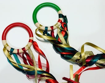 Christmas, red and green ribbon hand kite. Festive fairy wand with red, green and gold ribbons