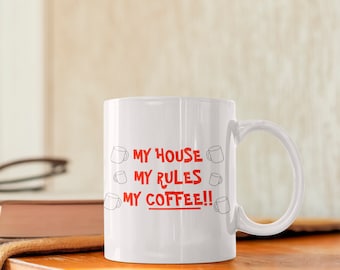 May include: White ceramic coffee mug with the text "MY HOUSE MY RULES MY COFFEE!!" in red lettering. The text is surrounded by small drawings of coffee cups.