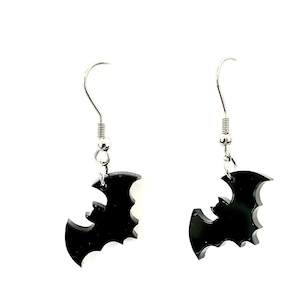 Könnte beinhalten: Ein Paar schwarze Fledermaus-Ohrringe mit silbernen Haken.