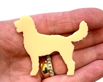 Könnte beinhalten: Eine cremefarbene Silhouette eines Hundes, der auf allen vieren steht und seinen Schwanz eingerollt hat. Die Silhouette besteht aus einem glatten, kunststoffartigen Material.