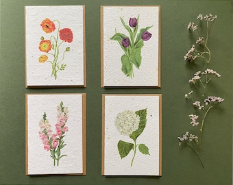 May include: Set of four blank greeting cards with floral illustrations. The cards feature a bouquet of purple tulips, a cluster of orange and yellow poppies, a bunch of pink snapdragons, and a white hydrangea.