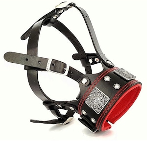 May include: Black leather dog muzzle with red stitching and silver accents. The muzzle has a decorative design on the front.