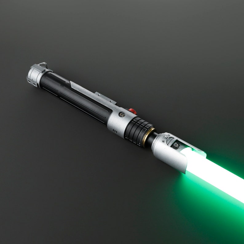 Peut inclure: Un sabre laser noir et argent avec une lame verte. Le sabre laser a un bouton rouge et une poign&eacute;e argent&eacute;e.