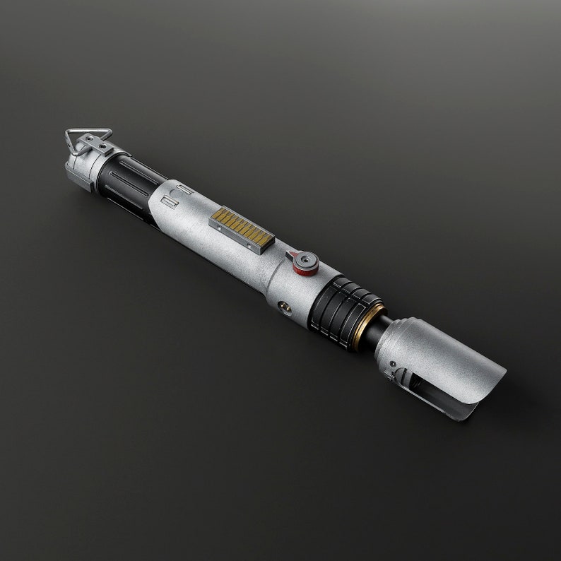 Peut inclure: Un sabre laser argent&eacute; et noir avec un accent dor&eacute; et un bouton rouge. Le sabre laser est sur un fond noir.