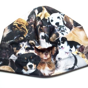 Może przedstawiać: Czarna czapka typu beanie z kolorowym nadrukiem różnych ras psów. Nadruk przedstawia różne rasy psów, w tym dalmatyńczyki, golden retrievery i labradory.