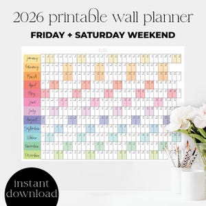 Peut inclure: Un planificateur mural imprimable 2026 avec une grille colorée. Le calendrier comprend le texte "FRIDAY + SATURDAY WEEKEND" et "téléchargement instantané". Les mois sont étiquetés en différentes couleurs. Un vase blanc avec des fleurs et des crayons est en arrière-plan.