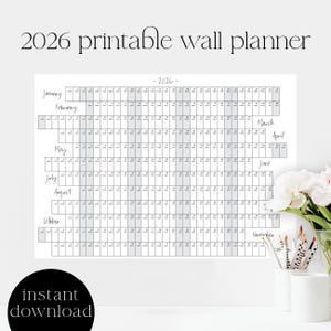Puede incluir: Un planificador de pared imprimible para el año 2026. El calendario está en blanco y negro con casillas sombreadas en gris para cada día. Los meses están listados verticalmente en el lado izquierdo del calendario. El texto "2026 printable wall planner" está en la parte superior del calendario.
