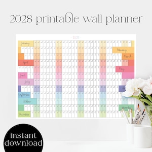 Peut inclure: Un planificateur mural imprimable 2028 avec un design coloré. Le calendrier présente une mise en page en grille avec chaque mois étiqueté dans une couleur pastel différente. Les mots "téléchargement instantané" sont en bas.