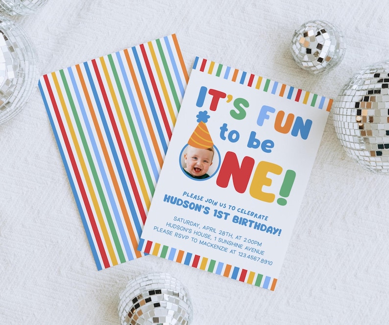 Pu&ograve; includere: Un colorato invito di compleanno con la scritta "IT'S FUN to be ONE!" e una foto di un bambino con un cappello da festa. L'invito ha un design a righe sul retro ed &egrave; circondato da sfere da discoteca.