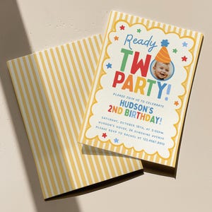 May include: A rectangular birthday invitation card and matching envelope featuring yellow and white vertical stripes. The card has a scalloped white border with colourful stars and text reading Ready TWO PARTY! Hudson's 2nd Birthday with details.
