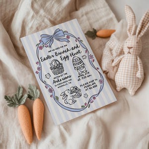 May include: An Easter Brunch and Egg Hunt invitation with a blue bow and floral accents. The invitation includes illustrations of an Easter basket, decorated egg, and a bunny. A stuffed bunny and felt carrots are also in the image.