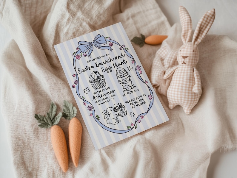 May include: An Easter Brunch and Egg Hunt invitation with a blue bow and floral accents. The invitation includes illustrations of an Easter basket, decorated egg, and a bunny. A stuffed bunny and felt carrots are also in the image.