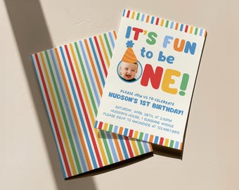 May include: A birthday invitation with the text "IT'S FUN to be ONE!" in colorful letters. The invitation includes a photo of a baby wearing a party hat. The back of the invitation has a striped pattern in various colors.