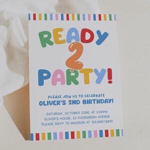 May include: A white invitation card with colorful text that reads "READY 2 PARTY!" for Oliver's 2nd birthday. The card includes the date, time, location, and RSVP information. The design features a rainbow border.