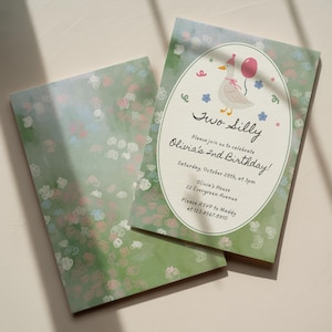 May include: A birthday invitation card featuring a green background with white, pink, and blue flower illustrations. An oval center displays a cartoon duck wearing a pink party hat and holding a pink balloon, with text reading Two Silly, Olivia's 2nd Birthday, Saturday, October 28th, at 3pm, Olivia's House, 22 Evergreen Avenue, Please RSVP to Maddy at 123.4567.8910.