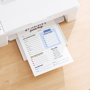 May include: A white printer printing a "My Teacher's Favorite Things" worksheet. The worksheet includes sections for favorite things, a classroom wishlist, and extra information. The text is in black, blue, and pink.