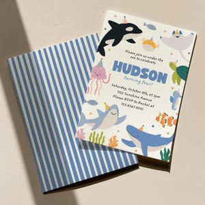 May include: A birthday invitation with an ocean theme. The invitation features illustrations of sea creatures, including a whale, shark, and jellyfish. The text reads "HUDSON turning four!" and includes event details. A blue and white striped envelope is behind the invitation.
