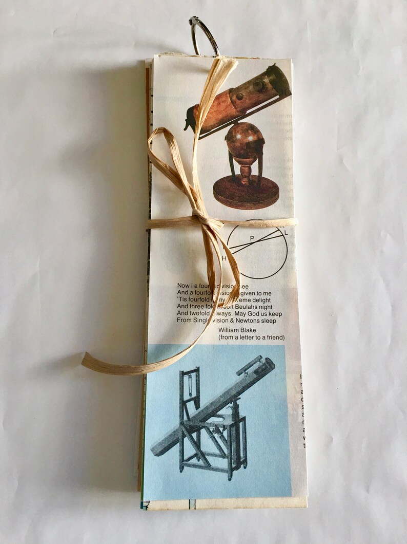 May include: A vintage book with a brown ribbon tied around it. The book features a black and white illustration of a telescope on a stand. The book includes a quote from William Blake: "Now I a fourfold vision see, And a fourfold vision given to me. Tis fourfold in my  eme delight, And three fold Beulahs night, And twofold Iways. May God us keep, From Single vision & Newtons sleep (from a letter to a friend)"