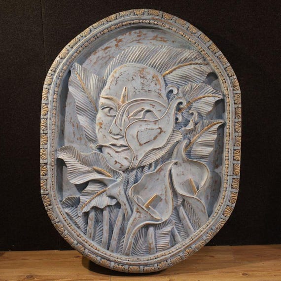 Bas-relief sculpture, stylized face with flowers, 20th century